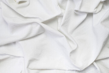 White crumpled natural cotton fabric top view. Natural linen background. Eco textiles. White wrinkled Fabric texture. Fabric backdrop  