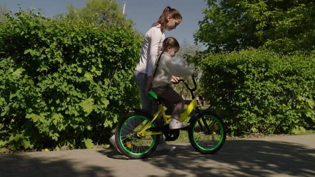 child learn ride bike. mother daughter girl park. happiness smile little child mom. dream family., playful girl, happy young family, cheerful girl learns ride bicycle summer, happy kid smiling riding