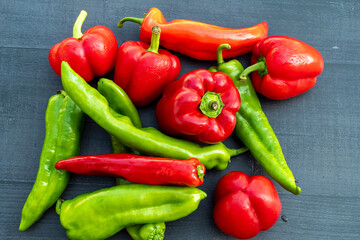 red and green organic peppers on black table