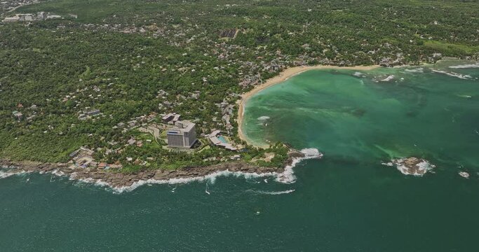 Unawatuna Sri Lanka Aerial v3 high altitude birds eye view flyover bay capturing Goda Gala Reef and rocky shoreline of Yaddehimulla, resort hotels along the beach - Shot with Mavic 3 Cine - April 2023