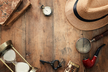 Concept image of investigation or private detective. Fedora hat, magnifying glass and vintage items...
