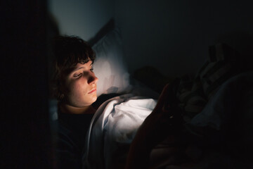 teenager uses gadget in dark