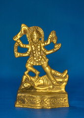Mini metallic sculpture of Hindu goddess Kali isolated in blue background 