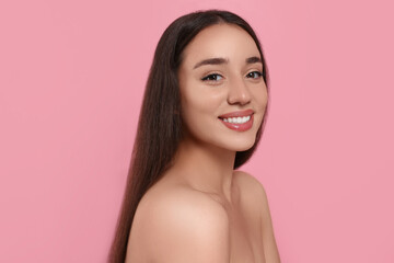Portrait of beautiful young woman with elegant makeup on pink background