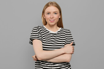 Obraz premium Portrait of beautiful young woman in striped t-shirt on grey background