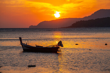 ..amazing yellow sky of sunrise above the island..scenic reflection of beautiful sunshine in the sea fishing boats are floating in the Rawai sea..