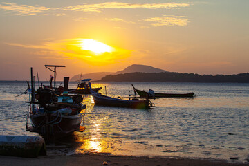 amazing yellow sky of sunrise above the island. .The brilliant yellow hue of the sky created a breathtaking scene as the sun slowly rose over the island..fishing boats parking on the golden sea.