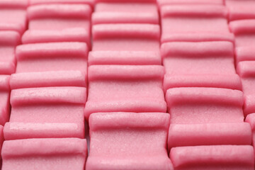 Tasty pink chewing gums as background, closeup