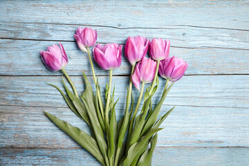 The natural beauty of purple tulips complements the rustic blue wooden setting