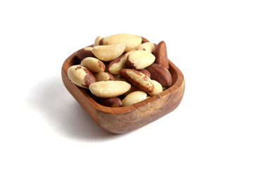 Brazil nuts in wooden bowl isolated on white. Peeled brazil nuts.