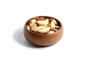Brazil nuts in wooden bowl isolated on white. Peeled brazil nuts.