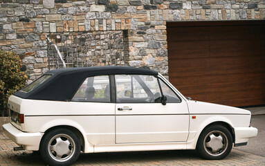 Retro cabriolet. Convertible vehicle. White 80s European compact convertible hatchback car.