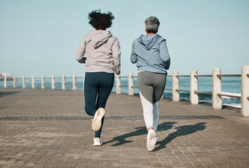 Fototapeta premium Back view, beach and friends running for fitness together as morning exercise for wellness and outdoor bonding. Health, endurance and people training for marathon in Cape Town for sports workout