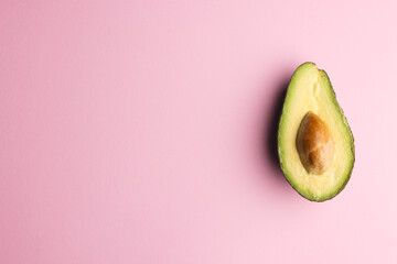 Close up of half of avocado and copy space on pink background © vectorfusionart