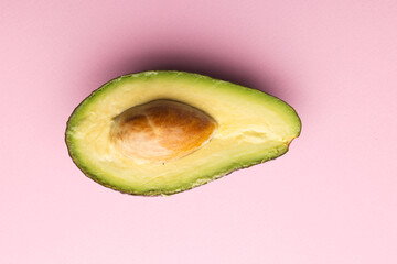 Close up of half of avocado and copy space on pink background © vectorfusionart