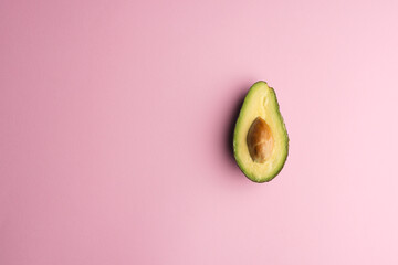 Close up of half of avocado and copy space on pink background © vectorfusionart