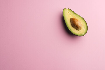 Close up of half of avocado and copy space on pink background © vectorfusionart