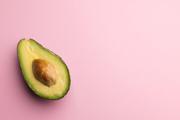 Close up of half of avocado and copy space on pink background © vectorfusionart