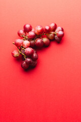 Close up of red grapes and copy space on red background