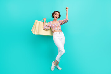 Full length photo of ecstatic overjoyed girl dressed flower print blouse hold new closes raising...