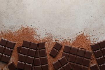Delicious dark chocolate and cocoa powder on light grey table, flat lay. Space for text