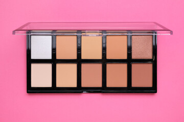 Colorful contouring palette on pink background, top view. Professional cosmetic product