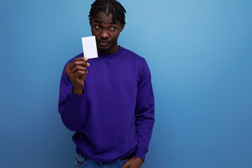 handsome african young man with dreadlocks holding a credit card