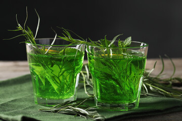 Glasses of refreshing tarragon drink on table, closeup