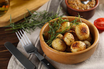 Delicious grilled potatoes with tarragon on table, closeup