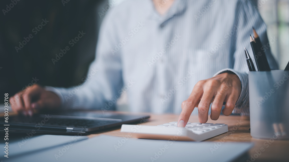 Aufkleber Businessman using calculator to calculate numbers ,profit and loss statement review of company performance ,Cost analysis and calculation of financial documents ,business account checking