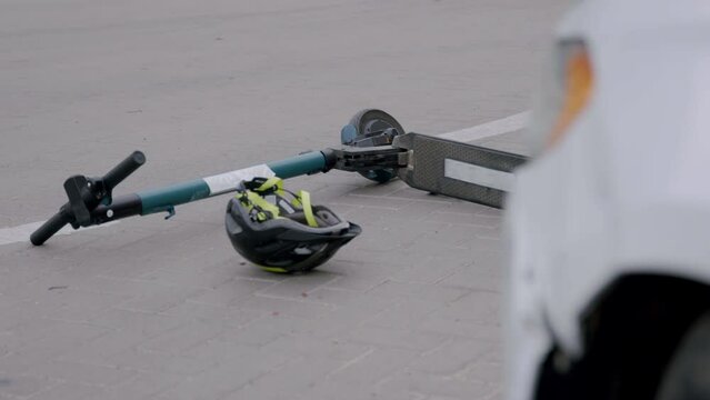 Close-up image of a damaged car that burns continuously. Road accident between a car and an electric scooter in an intersection. Concept for car insurance companies for their customers.