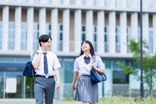 学校の前を歩く男女
