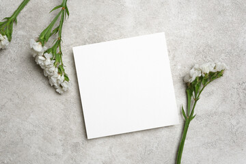 Paper square wish card mockup with white flowers decor, flat lay with copy space