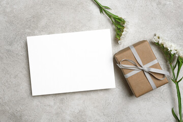 Greeting card mockup with gift box and flowers, blank card mock up with copy space