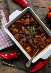 Spicy braised pork neck with bell peppers, tomatoes, onions, garlic, chili and herbs.
