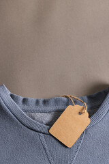 Close up of blue t shirt with tag and copy space on brown background