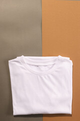 Close up of folded white t shirts and copy space on brown background