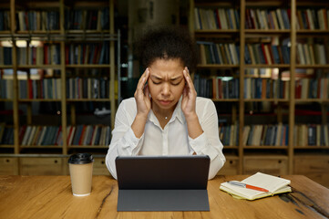Office worker touching head massaging temples suffering from headache or tension