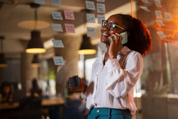 Happy businesswoman in office. Portrait of beautiful businesswoman using the phone. Woman talking to the phone.