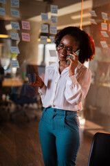 Happy businesswoman in office. Portrait of beautiful businesswoman using the phone. Woman talking to the phone.