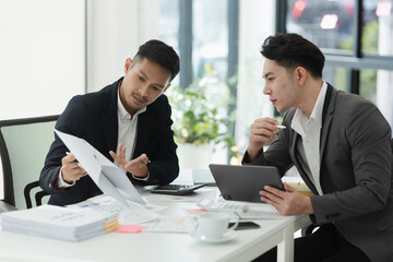 Two colleagues asian businessman working together to business finance trading at office desk.