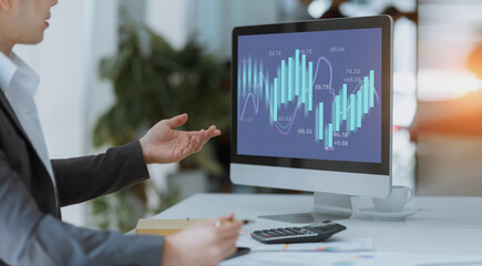 Technology and financial advisory services concert. Businessman working on digital desktop  computer with advisor showing plan of investment to clients at table office. Digital marketing.