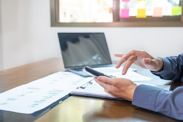 Businessmen bookkeeper hand use calculator and laptop doing account for paying tax on desk in working office