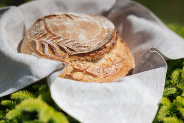 Close up of fresh wheat homemade bread on grey towel outdoors. Concept of healthy eating, home...