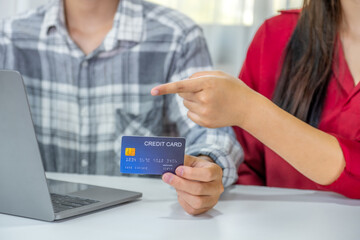 Young couple consumer hand holding mock up credit card, Ready to spend pay online shopping according to discount products via smartphone and laptop from home office