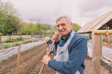 portrait of senior farmer outdoors in garden field
