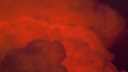 Vue rapprochée d'un cumulonimbus, aux reflets orangés, pendant le crépuscule