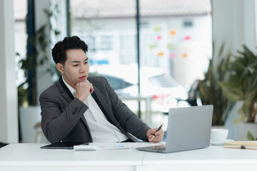 sad asian businessman sitting at desk in modern office, stressed man, problem, Worried young man businessman, 