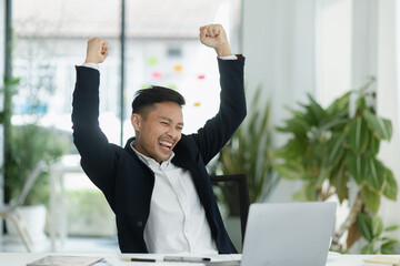 Success and excited Asian man sitting in creative office, Excited businessman or winner celebrate...