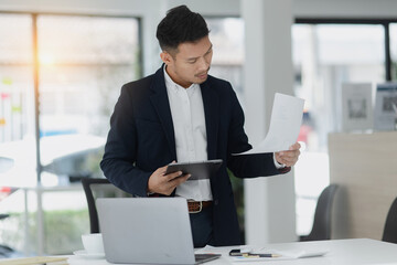 Portrait of candid happy asian businessman working in office.